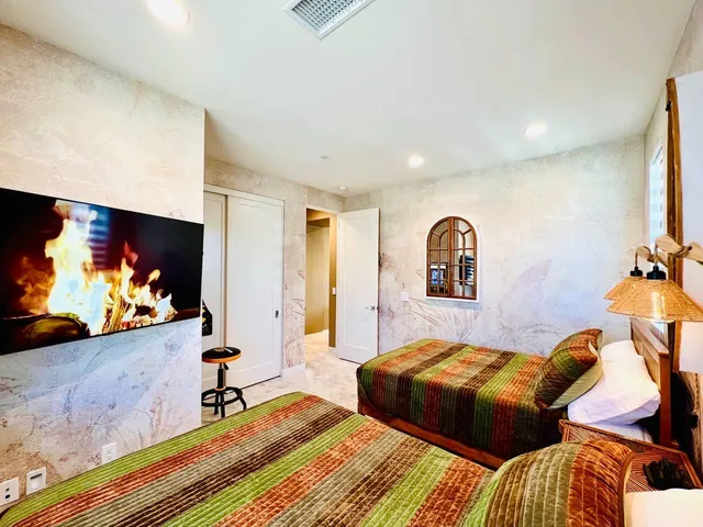 a bedroom with two beds and a flat screen tv