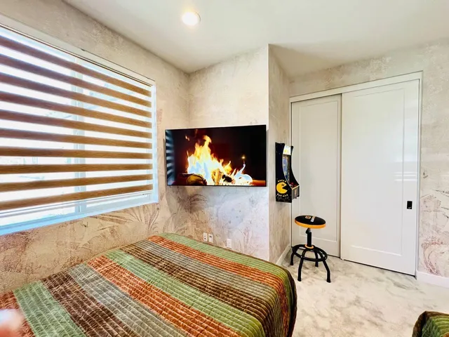 a bedroom with a bed and a painting on the wall