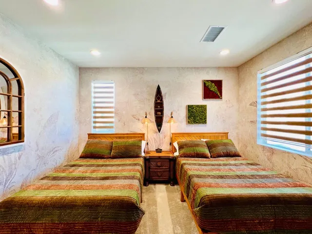 a bedroom with two beds and a window