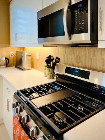 a kitchen with stove and cabinets