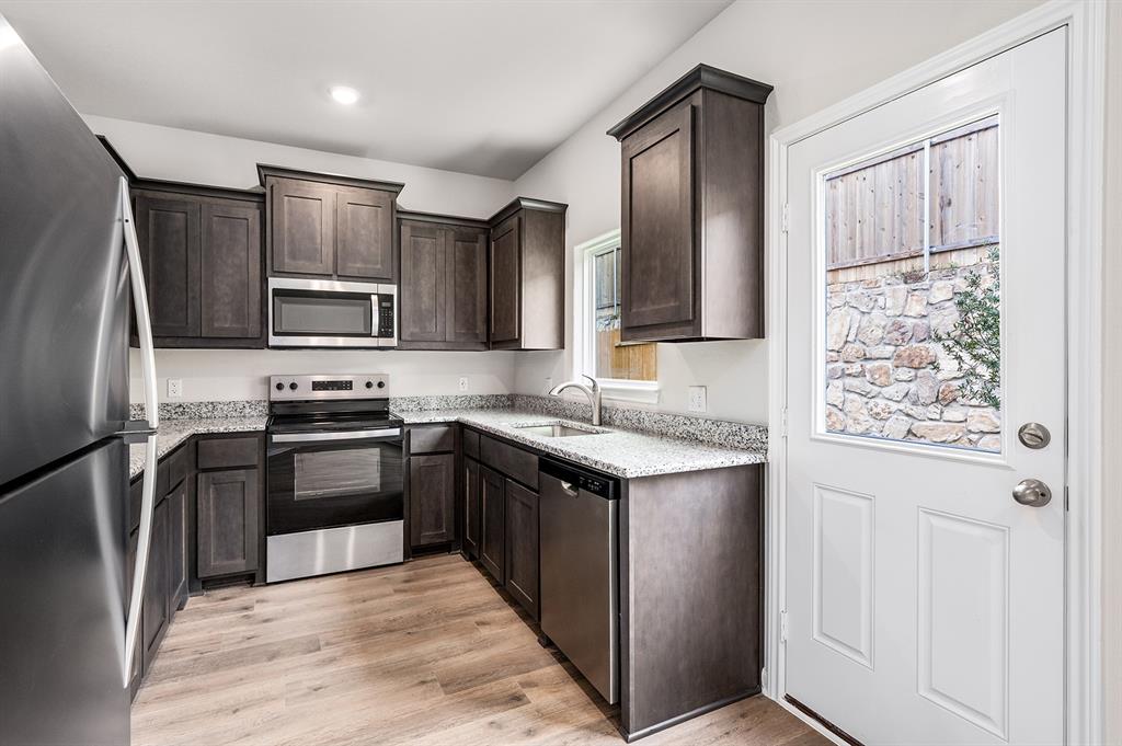 4256 Lava Frst Drive Dallas, TX 75241 - Photo 7 of 20 a kitchen with stainless steel appliances granite countertop a refrigerator stove microwave and sink