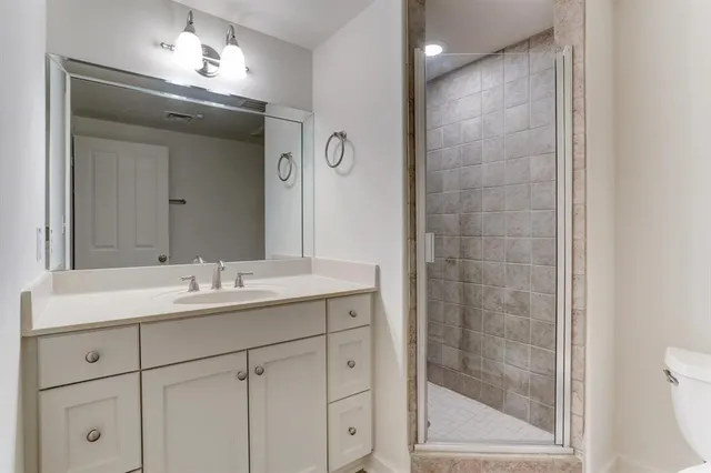 a bathroom with a double vanity sink mirror and shower