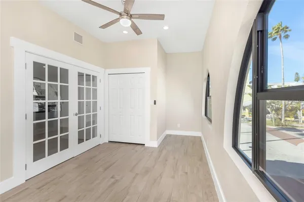 an empty room with wooden floor and windows