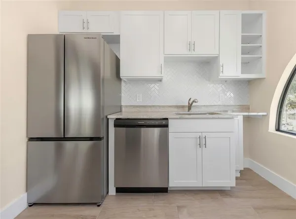 a kitchen with stainless steel appliances granite countertop a sink a stove and a microwave