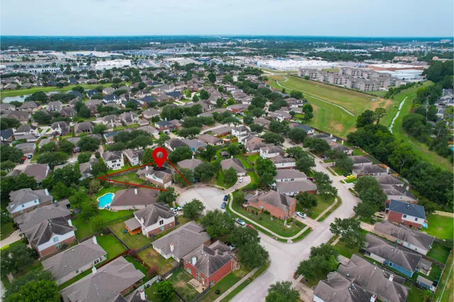 an aerial view of residential houses with outdoor space and swimming pool