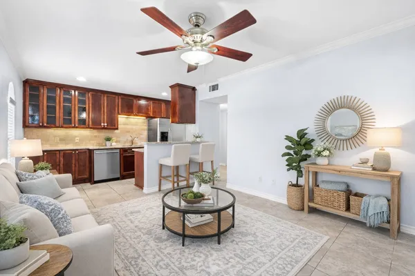 a living room with furniture kitchen and a chandelier