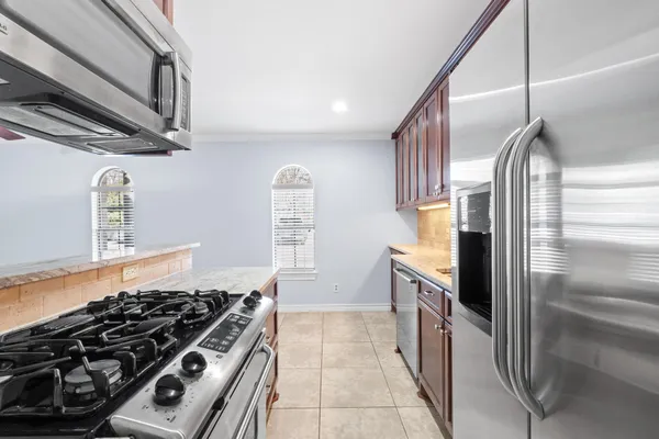 a kitchen with stainless steel appliances granite countertop a stove and a refrigerator