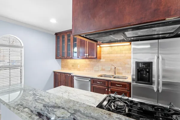 a kitchen with stainless steel appliances granite countertop a refrigerator and a stove
