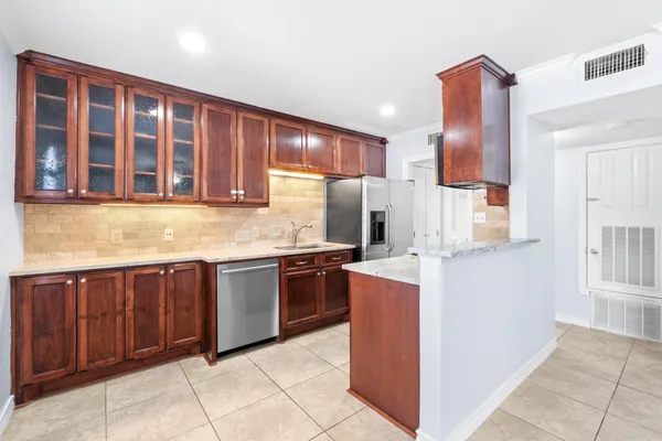 a kitchen with stainless steel appliances granite countertop wooden cabinets a sink and dishwasher