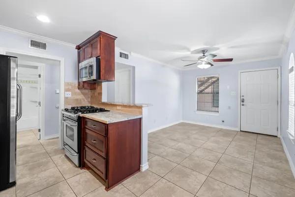 a kitchen with stainless steel appliances granite countertop a stove a refrigerator and a cabinets