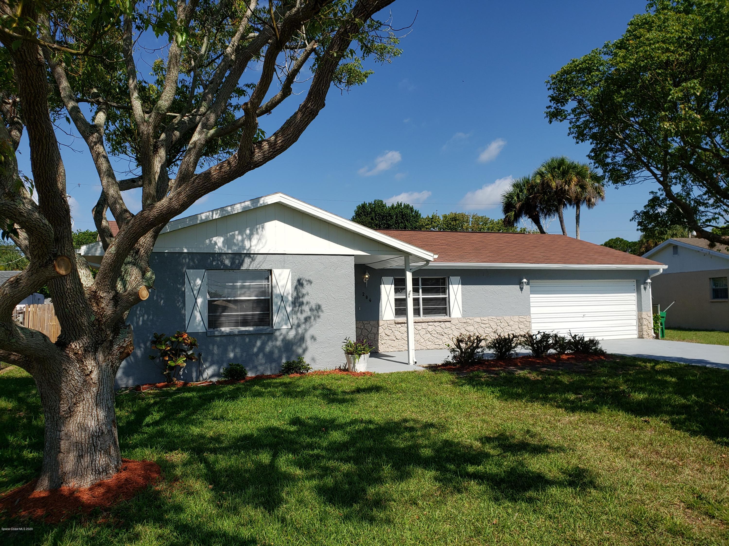 284 Jablo Avenue Cocoa, FL 32927 - Photo 1 of 20 a backyard of a house with potted plants and large trees
