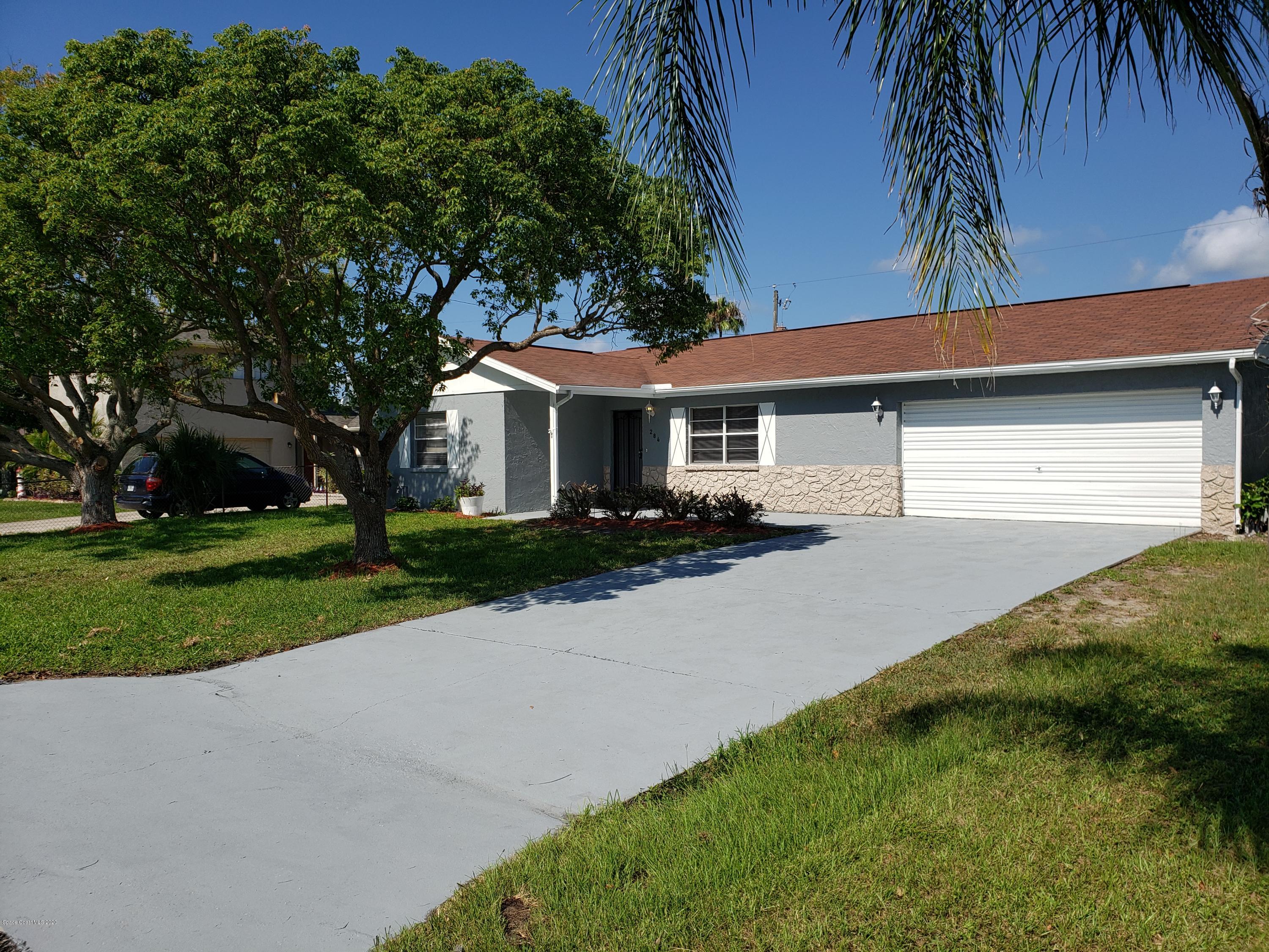284 Jablo Avenue Cocoa, FL 32927 - Photo 2 of 20 a front view of a house with a yard and garage