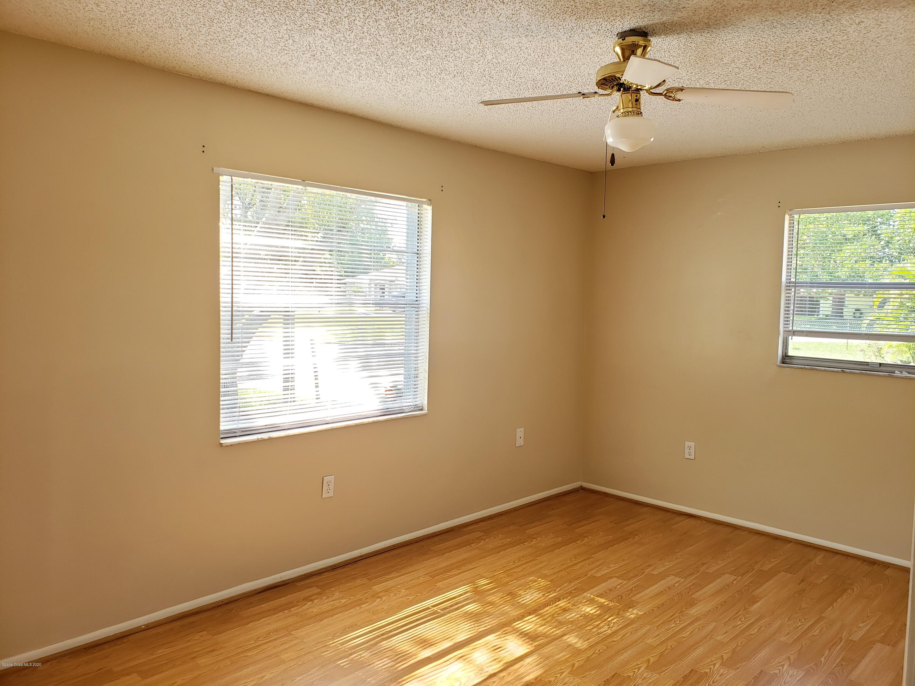 284 Jablo Avenue Cocoa, FL 32927 - Photo 12 of 20 a view of empty room with wooden floor and fan