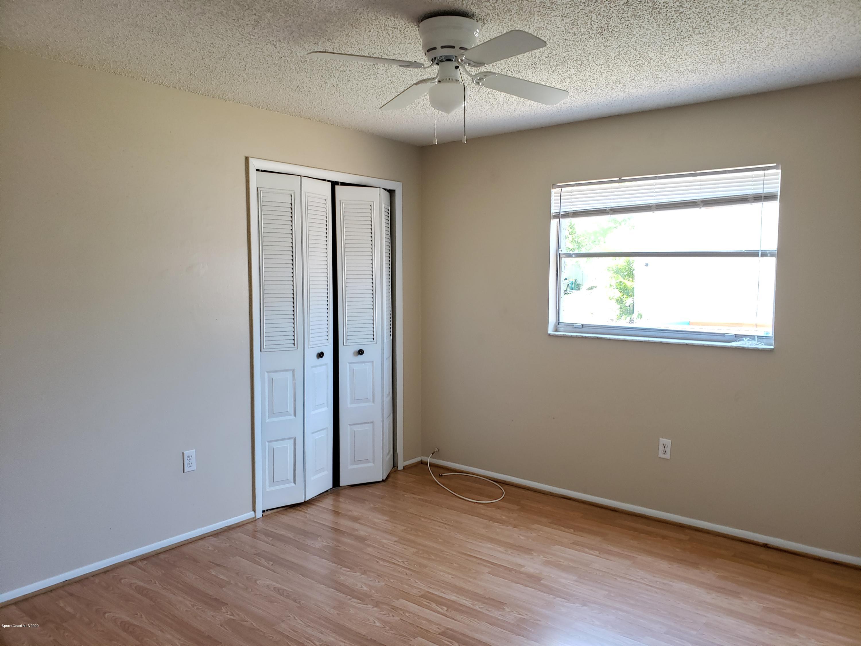 284 Jablo Avenue Cocoa, FL 32927 - Photo 13 of 20 a view of an empty room with wooden floor and a window