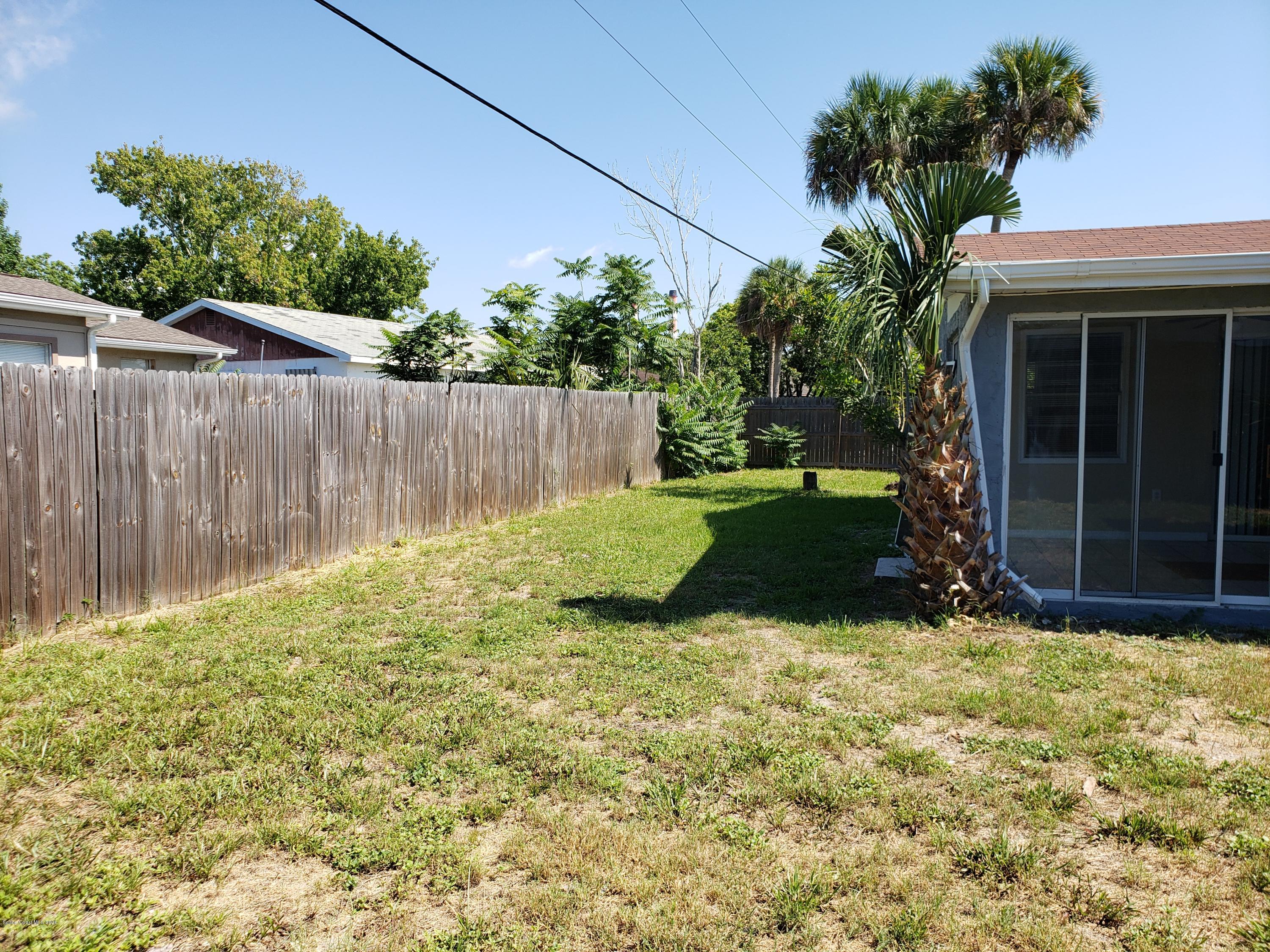 284 Jablo Avenue Cocoa, FL 32927 - Photo 18 of 20 a view of backyard with wooden fence and a bench