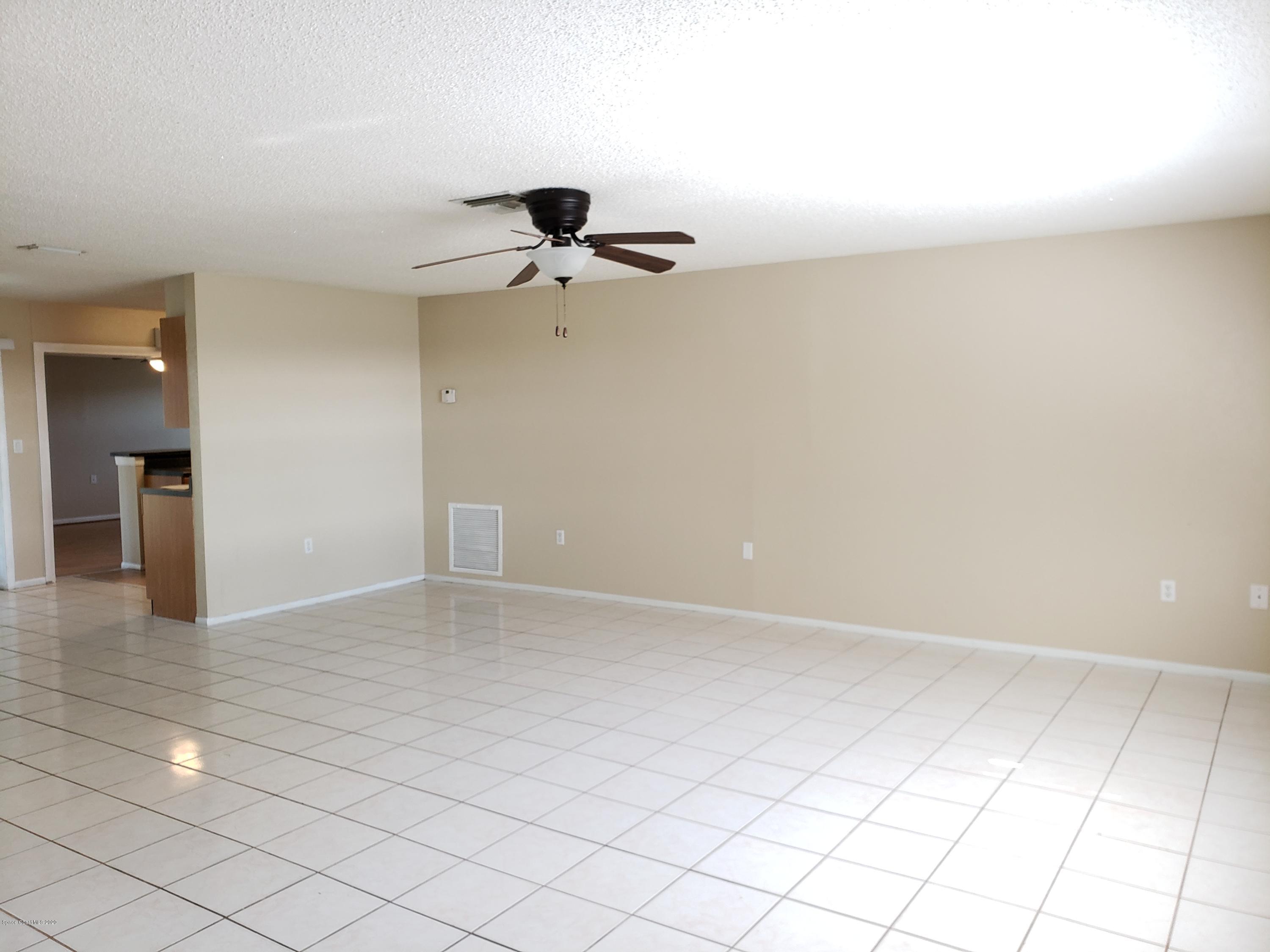 284 Jablo Avenue Cocoa, FL 32927 - Photo 4 of 20 an empty room with a ceiling fan and carpet