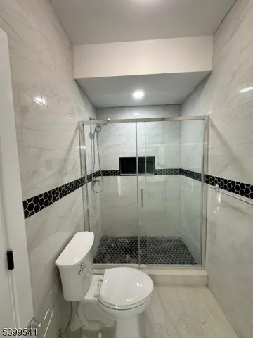 a bathroom with a shower a toilet and a shower