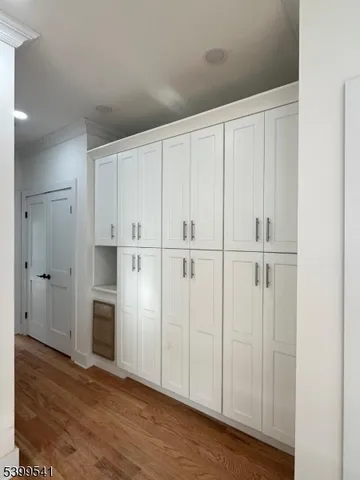 a view of empty room with wooden floor and cabinet