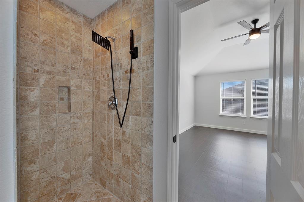 605 Clearbrook Street Azle, TX 76020 - Photo 19 of 33 Tiled shower enclosure featuring a black multi-function shower system and recessed niche