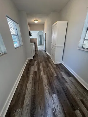 a view of a hallway with wooden floor and staircase