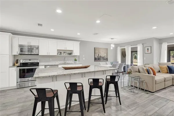 a kitchen with granite countertop a sink stainless steel appliances and cabinets