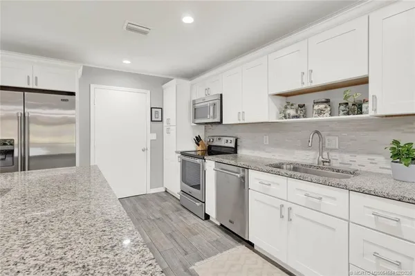 a kitchen with granite countertop cabinets stainless steel appliances a sink and a counter top space