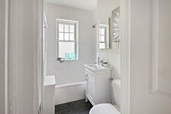 52 Strathmore Road, Unit 25 Boston, MA 02135 - Photo 10 of 12 a bathroom with a toilet sink and mirror