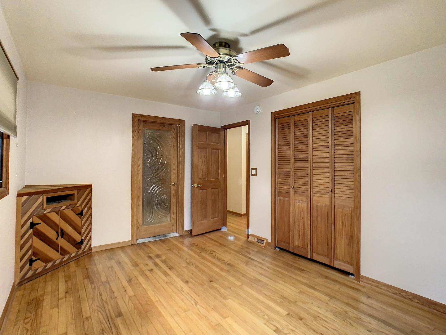 4705 Timberlane Road Crystal Lake, IL 60014 - Photo 21 of 29 a view of an empty room with wooden floor and a ceiling fan