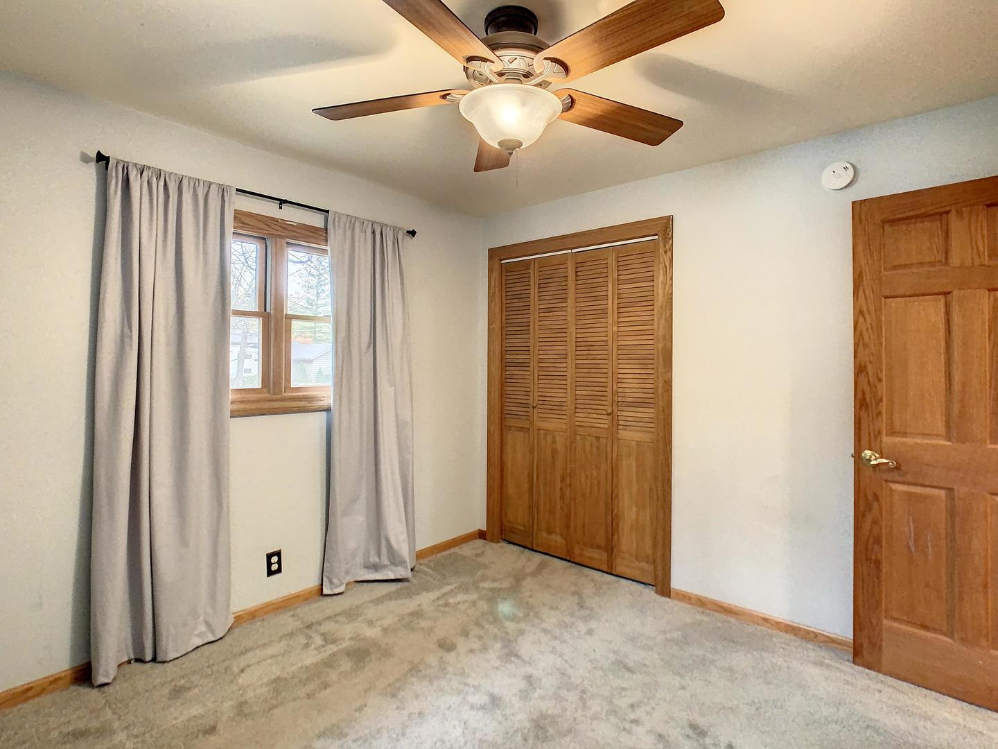 4705 Timberlane Road Crystal Lake, IL 60014 - Photo 23 of 29 an empty room with closet and a chandelier fan