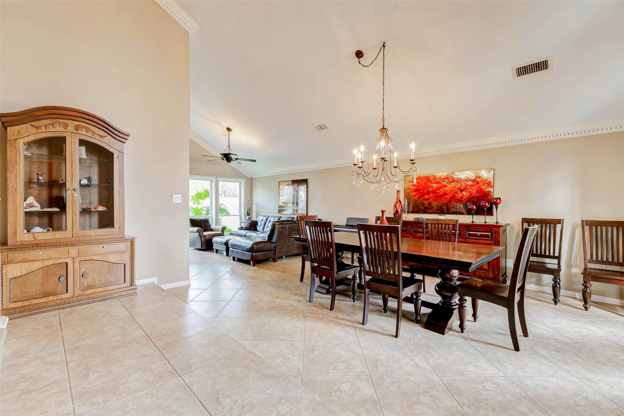 15811 Spring Forest Drive Houston, TX 77059 - Photo 4 of 27 This elegant formal dining area offers a spacious setting for memorable gatherings, featuring a grand table under a sparkling chandelier, seamlessly connecting to the inviting living space.