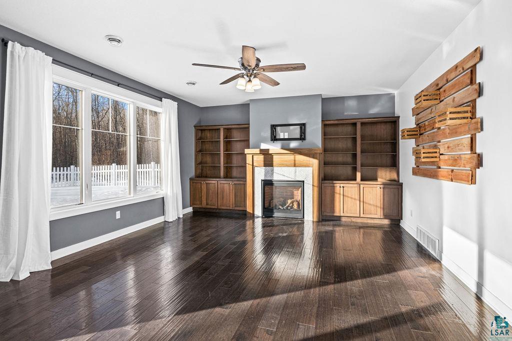 3879 Okerstrom Road Hermantown, MN 55811 - Photo 12 of 32 Unfurnished living room with ceiling fan, dark wood finished floors, and a high end fireplace