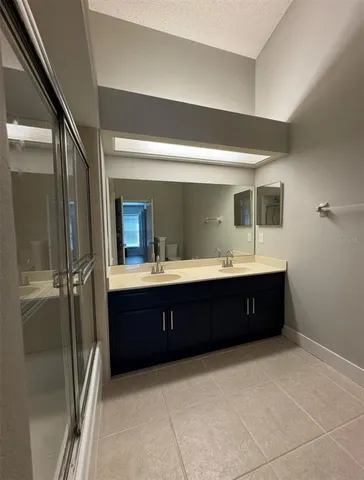a spacious bathroom with a double vanity sink and mirror