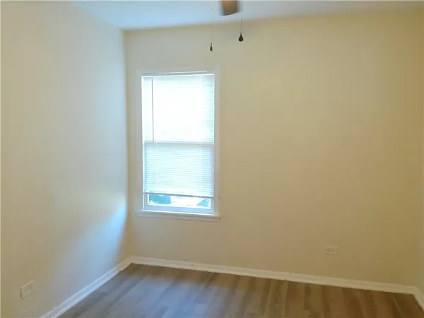 a view of a small space with wooden floor and a window