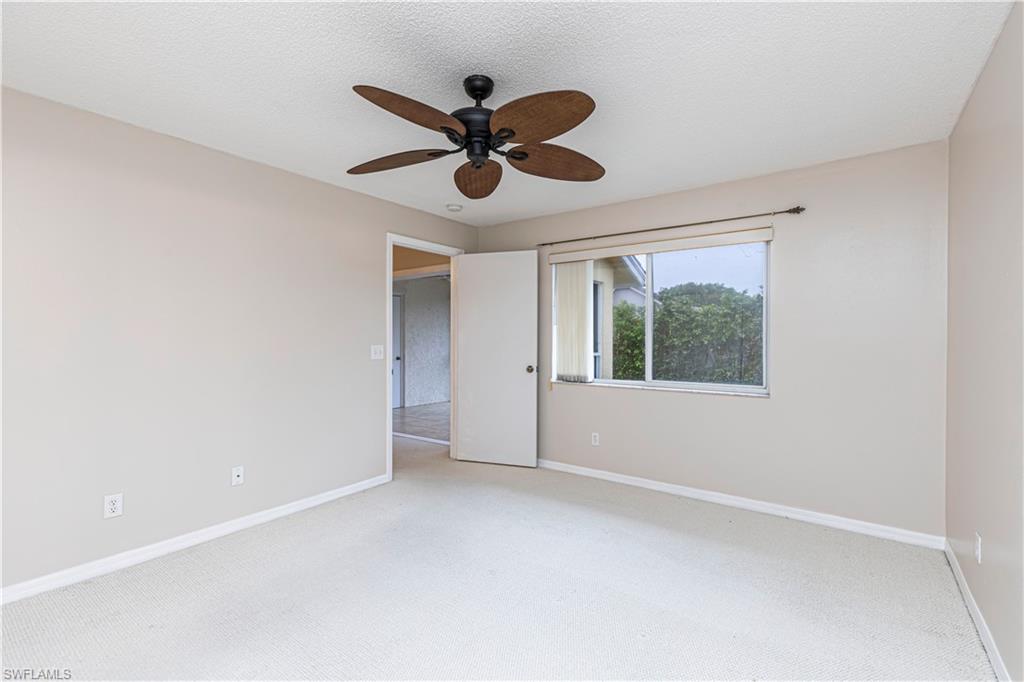 7761 Jewel Lane, Unit 202 Naples, FL 34109 - Photo 17 of 27 Carpeted spare room with a textured ceiling and ceiling fan