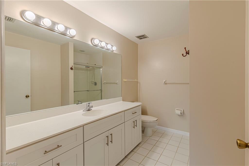 7761 Jewel Lane, Unit 202 Naples, FL 34109 - Photo 20 of 27 Bathroom featuring tile patterned floors, an enclosed shower, vanity, and toilet