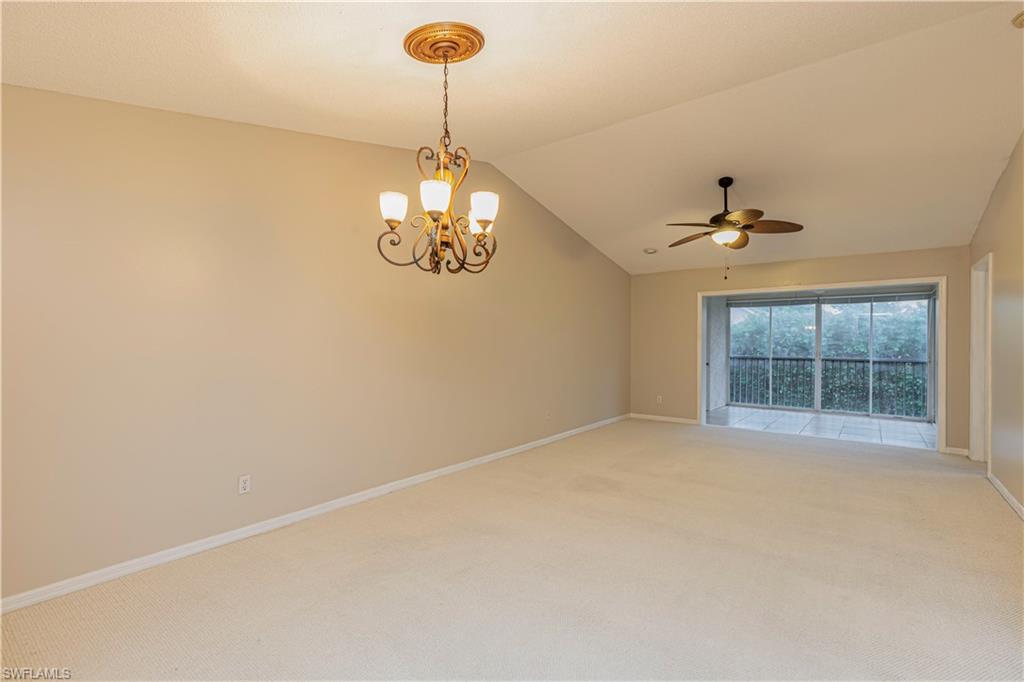 7761 Jewel Lane, Unit 202 Naples, FL 34109 - Photo 4 of 27 Carpeted spare room with ceiling fan with notable chandelier and lofted ceiling