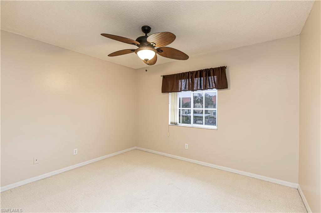 7761 Jewel Lane, Unit 202 Naples, FL 34109 - Photo 8 of 27 Carpeted empty room with ceiling fan and a textured ceiling