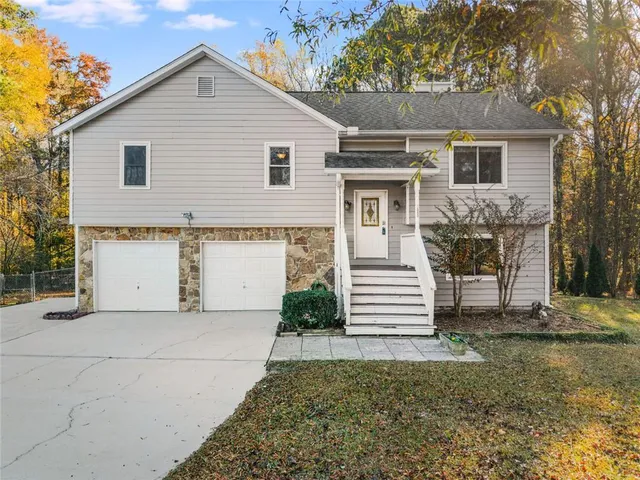 a view of a white house next to a yard