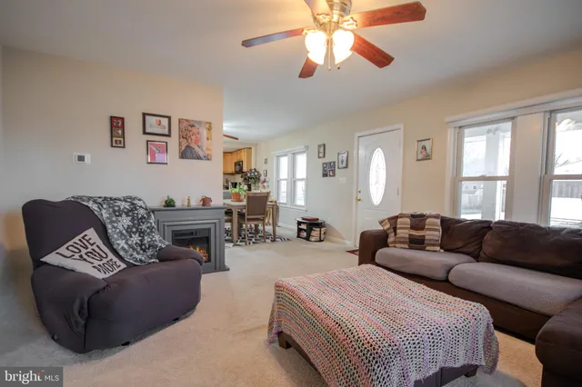a living room with furniture a large window and a chandelier