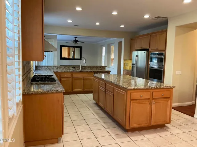 a kitchen with stainless steel appliances granite countertop a sink stove and cabinets