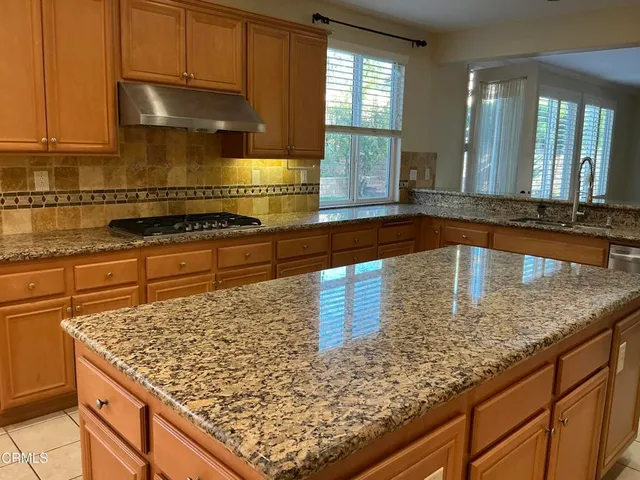 a kitchen with granite countertop a refrigerator and a sink