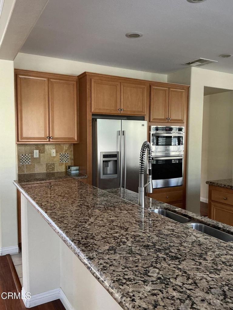 13687 Blue Ridge Way Moorpark, CA 93021 - Photo 14 of 56 a kitchen with granite countertop a sink stove and refrigerator