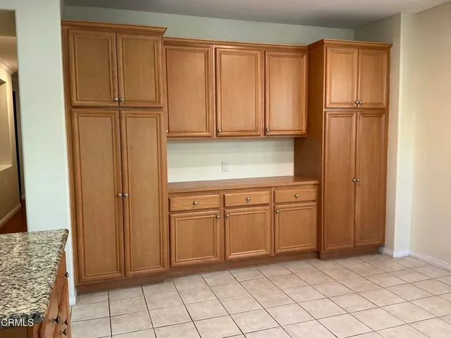 a kitchen with granite countertop a sink a stove and cabinets