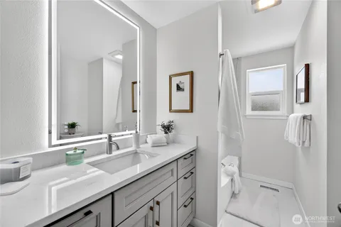 a bathroom with a sink and mirror with toilet