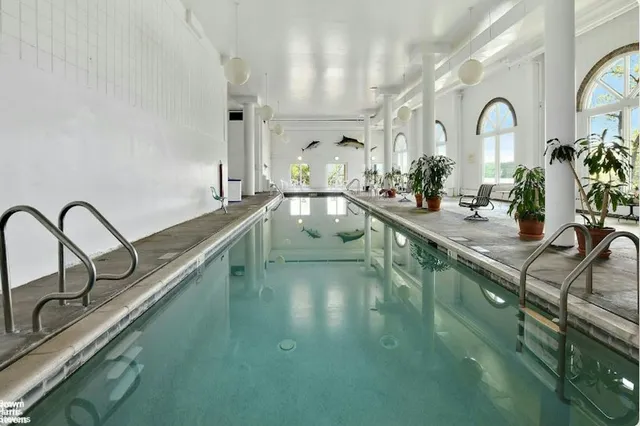 a view of a kitchen with kitchen island stainless steel appliances a sink and living room view