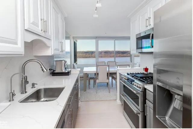 a kitchen with stainless steel appliances a sink stove and cabinets