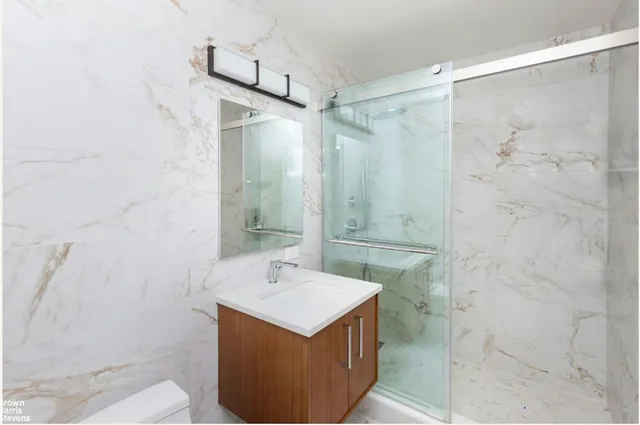 a bathroom with a sink mirror and shower
