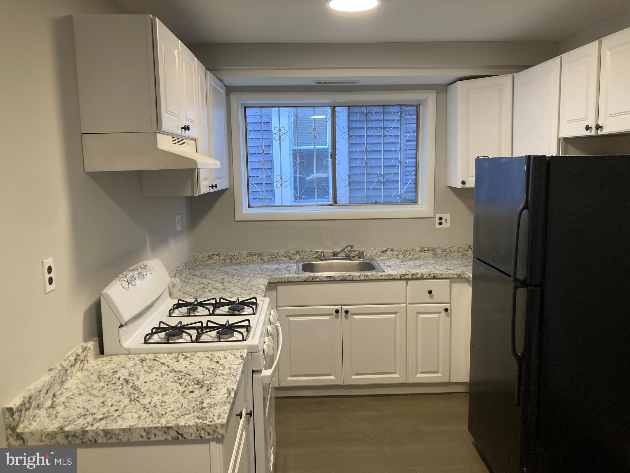 712 Alabama Avenue Southeast Washington, DC 20032 - Photo 4 of 15 a kitchen with a stove a refrigerator and a sink