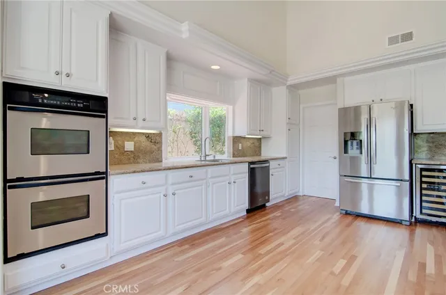 a kitchen with stainless steel appliances a refrigerator and a stove top oven