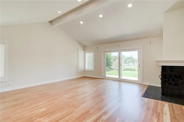 an empty room with wooden floor and fireplace